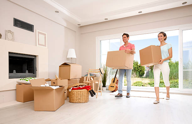 istock Couple carrying cardboard boxes and smiling 516682034