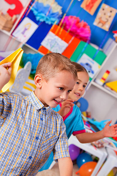 istock Group kids holding origami airplane in kindergarten 516682398