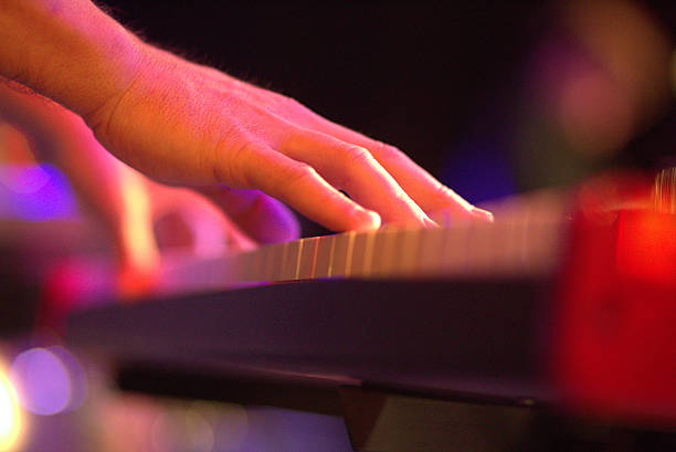 istock Musician playing on electric keyboard in studio on black 516683430