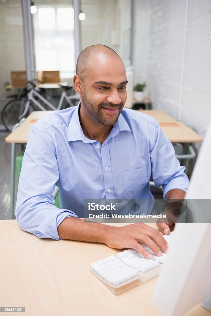 Businessman using computer at desk Young businessman using computer at office desk 30-39 Years Stock Photo