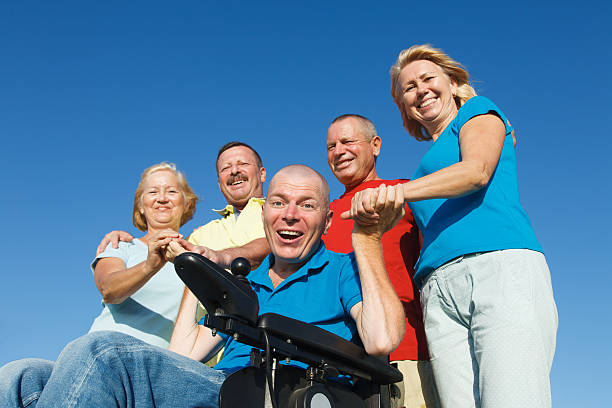 disabile uomo con la famiglia all'aperto. - senior adult wheelchair community family foto e immagini stock