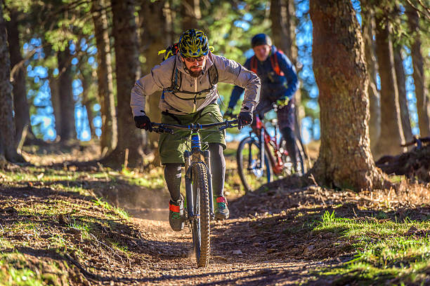 People enjoying mountain biking People enjoying mountain biking in forest with trees in background. mountain bike stock pictures, royalty-free photos & images