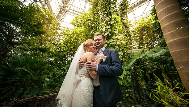 istock Bride and groom hugging under palm at rain forest 516685645