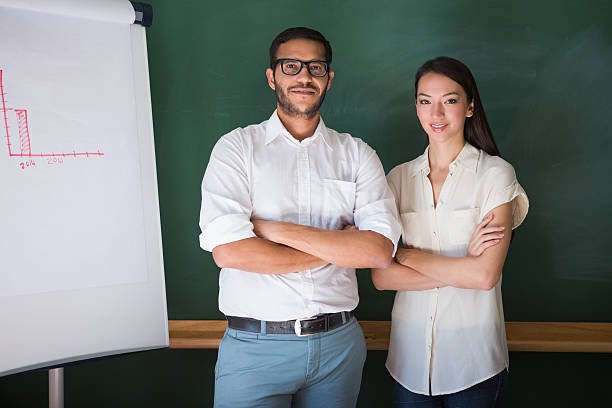 istock Two confident business people with arms crossed in office 516686331