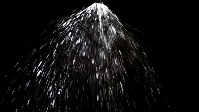 Sprinkler sprinkling water on black background
