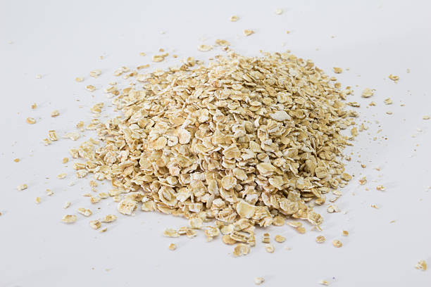 istock Little heap of raw rolled oats on white 516687334