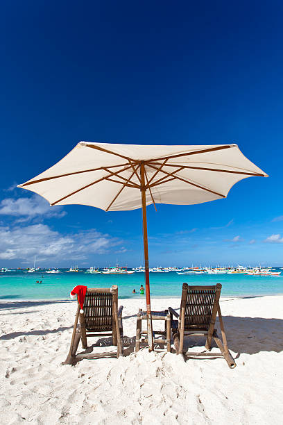 istock Sun umbrella with Santa Claus Hat on chairs 516688333