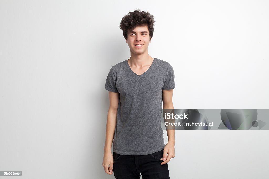 Hermosa adolescente de sexo masculino sonriendo y posando sobre fondo blanco - Foto de stock de Adolescente libre de derechos