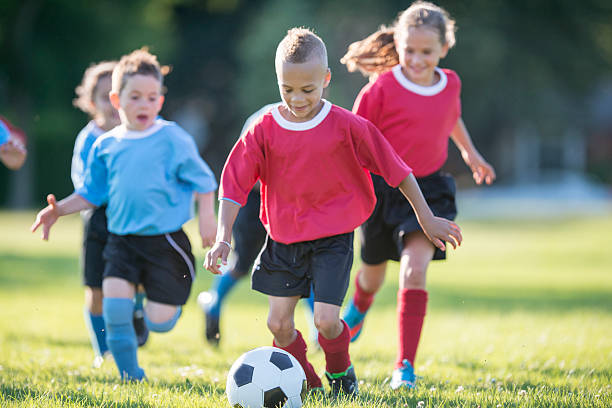 istock Little Boy Dribbling the Ball Up the Field 516689210