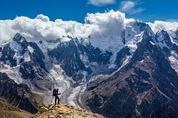 istock Hiker with backpack standing on mountain top and enjoying scene 516690680