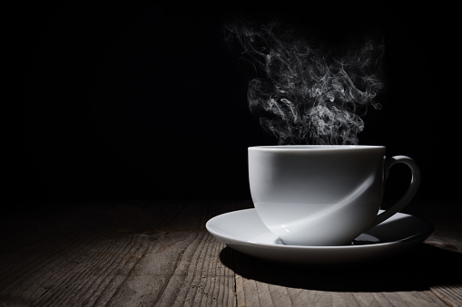 Hot cup of coffee or tea with steam and copy space