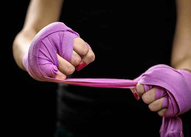 istock Woman is wrapping hands with purple boxing wraps 516693148