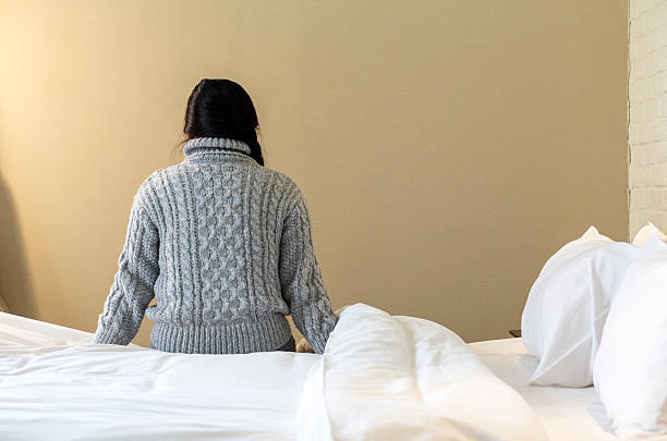 istock girl sitting beside bed 516693362