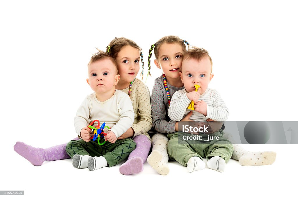Two pairs, sets of twins - boys and girls. Having twins twice. Two pairs, sets of twin baby and twin children. Identical twin sisters are hugging identical twin brothers. Twin Stock Photo