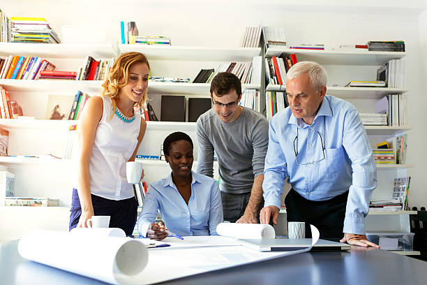 istock Multi-Ethnic Team of architects Examining Blue Print. 516693744