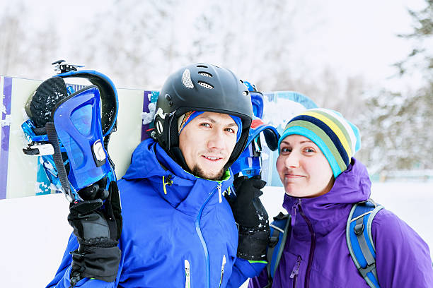 istock man and woman with snowboard 516694458