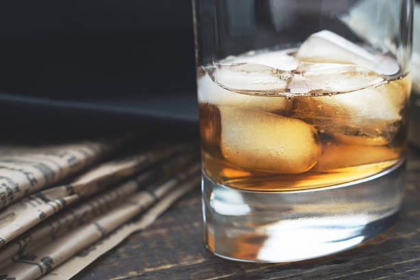 istock Whiskey with ice  and blurred newspaper on the horizontal 516714490