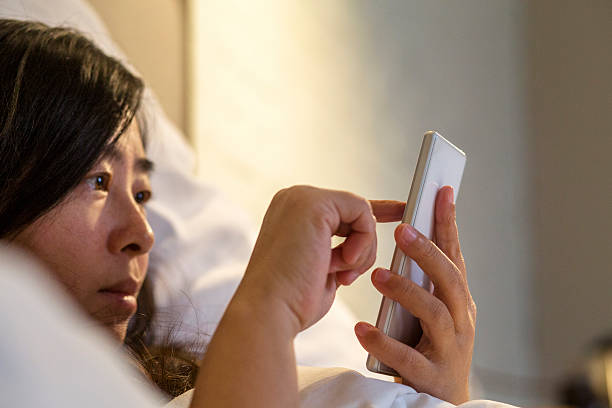 istock finger touching screen of smart phone on bed 516714990