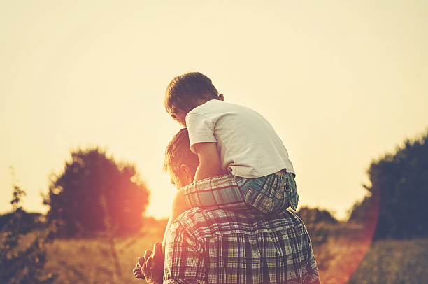 Fatherhood Father and son together  on shoulders stock pictures, royalty-free photos & images