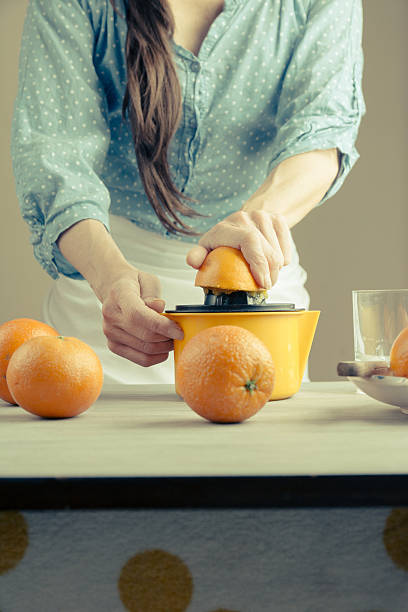 istock woman squeezing oranges for juice 516716558