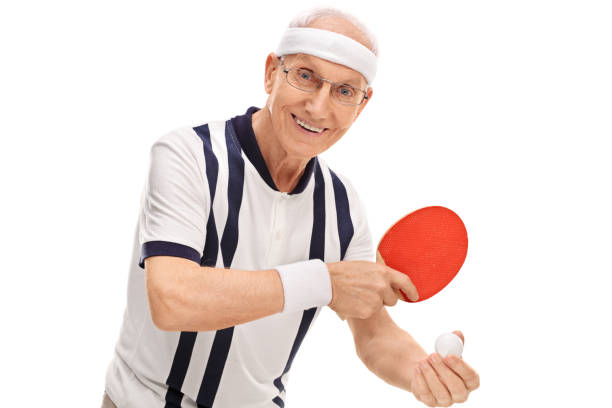 attivo senior giocare a ping-pong - tennis men indoors serving foto e immagini stock