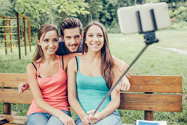 istock Cheerful teenagers taking selfies with a selfie-stick 516718390