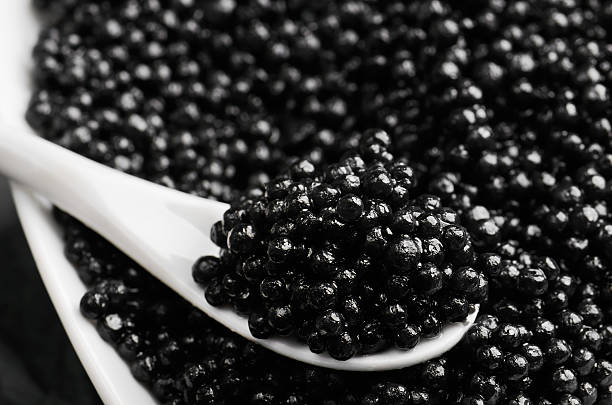 istock spoon of black caviar close-up in a white bowl 516720896