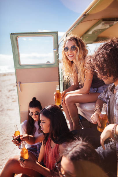 istock Hipster Multi-Ethnic Group Sitting in Back of Van Drinking Beer 516720980