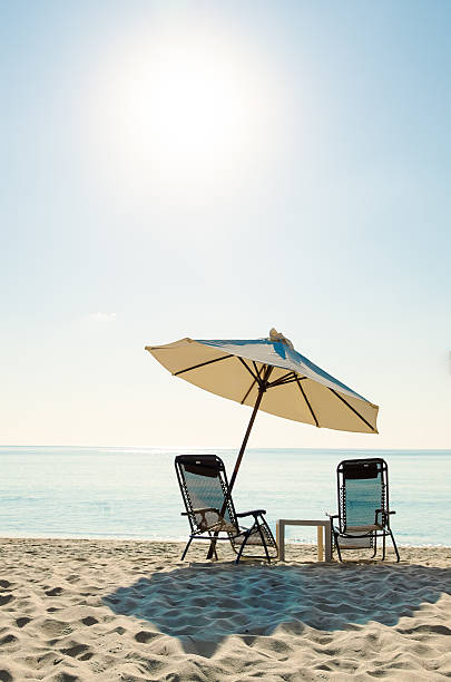 istock Beach chairs on sand beach with sky and sun 516724044