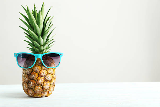 Ripe pineapple on a white wooden table stock photo