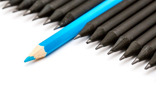 Blue pencil standing out from the row of black pencils.