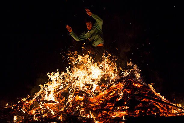 Sofia, Bulgaria - March 13, 2016: An young man is participating in a fire ritual during a celebration of Sirni Zagovezni. It is believed that evil spirits are chased away with this fire rituals.