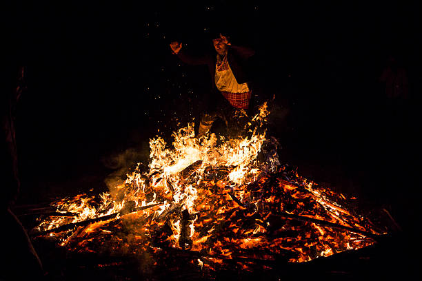 Sofia, Bulgaria - March 13, 2016: An young man is participating in a fire ritual during a celebration of Sirni Zagovezni. It is believed that evil spirits are chased away with this fire rituals.