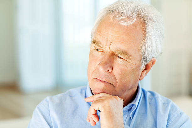 istock Serious Man Looking Away With Hand On Chin At Home 516726573