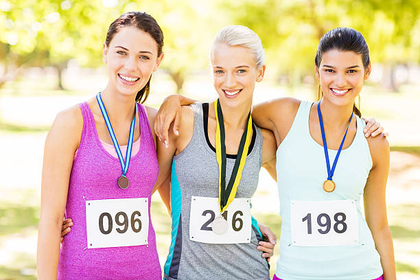 istock Confident Marathon Runners With Medals In Park 516726577