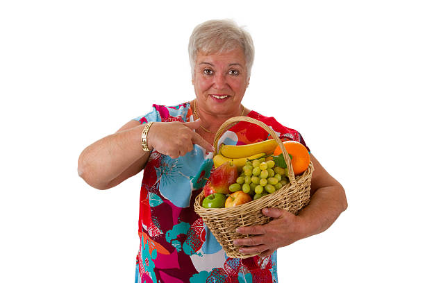 istock Female senior holding fruit basket 516726796