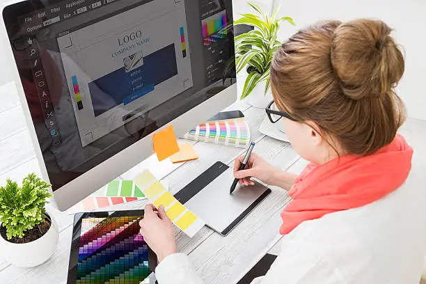 Photo of Graphic designer at work. Color samples.