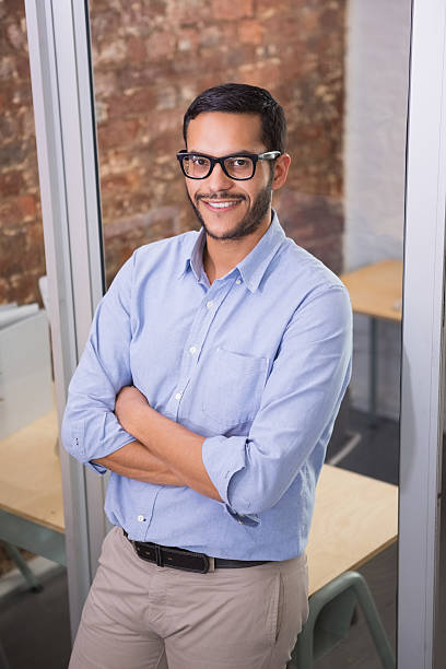 istock Smiling businessman with arms crossed at office 516729389
