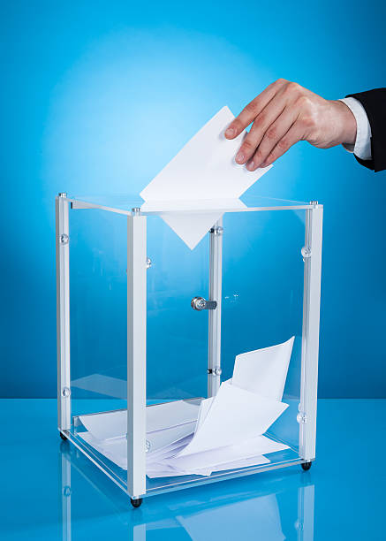 istock Businessman Putting Paper In Polling Box 516729499
