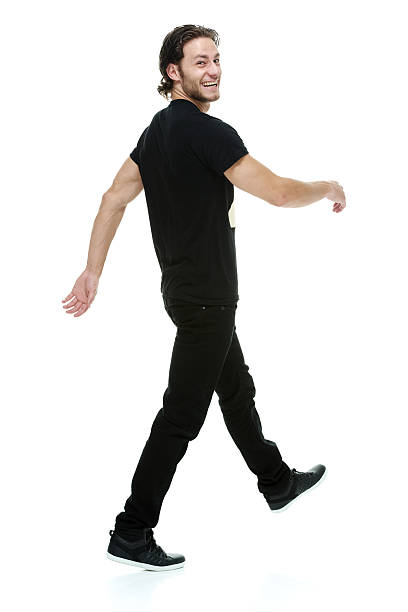 istock Rear view of smiling man walking & looking at camera 516730299