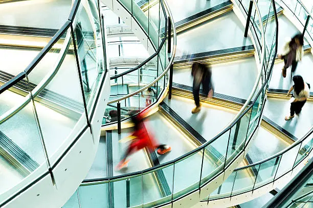 Motion blur of people on a contemporary spiral staircase.