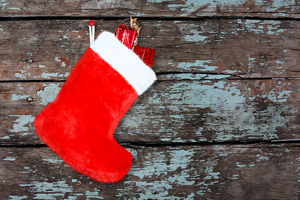 istock Red christmas boot with gifts on background wooden wall 516733183
