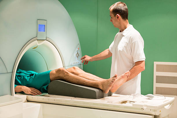 Patient in MRI scanner Patient in MRI scanner male nurse male healthcare and medicine technician stock pictures, royalty-free photos & images