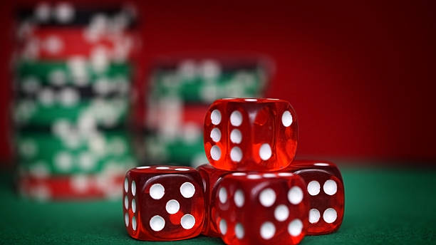 istock Red dice and casino chips on green table 516760328
