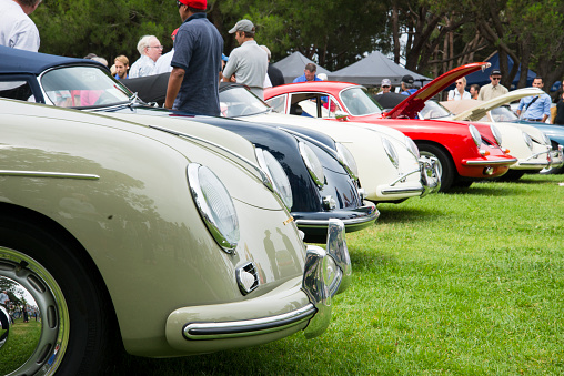 Dana Point, CA, USA - July 21, 2013: A crowd of people gathering around and enjoying a row of several immaculately maintained vintage Porsche Speedsters and 356's, at the Annual 356 Club of Southern California Dana Point Concours, which took place at Lantern Bay Park.  The colors, from left to right, are Gray Green, Azure Blue, Ivory, Signal Red, Sahara Beige, and Meissen Blue.