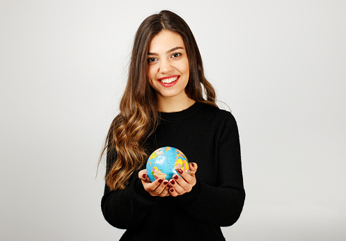 Young woman holding world in hands.