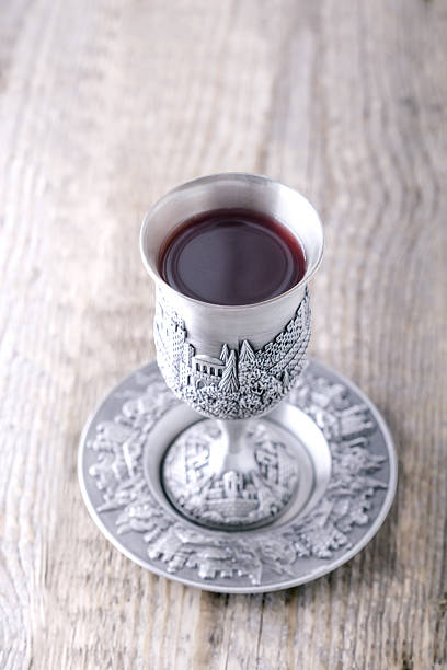 Kiddush cup Silver kiddush cup with wine on the wooden table jewish sabbath photos stock pictures, royalty-free photos & images