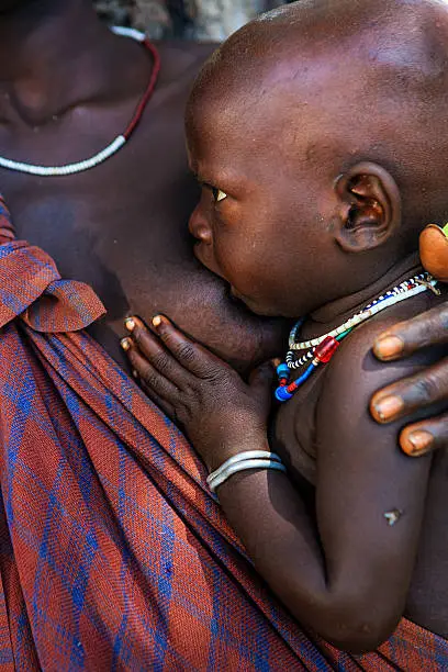 Young mother from Mursi tribe breasfeeding her baby.  Mursi tribe are probably the last groups in Africa amongst whom it is still the norm for women to wear large pottery or wooden discs or ‘plates’ in their lower lips.http://bem.2be.pl/IS/ethiopia_380.jpg