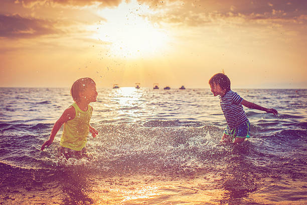 enfants sur la plage - spraying beaches summer sunlight photos et images de collection