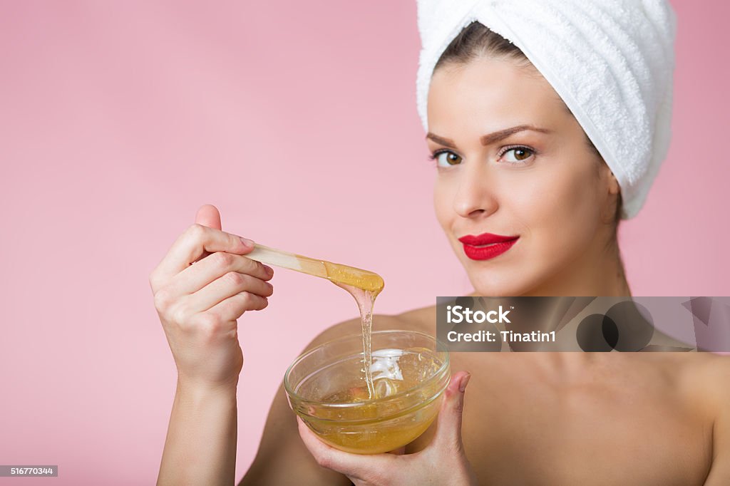 Sugaring beauty treatment Woman holding sugar hair removing paste Honey Stock Photo